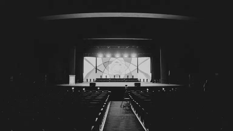 A stage performance with audience in dark theater